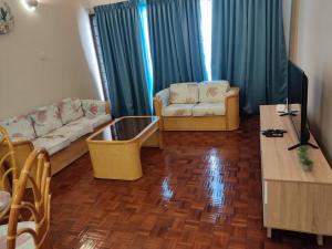 uma sala de estar com dois sofás e uma televisão em Tanjung tuan regency private PD em Porto Dickson
