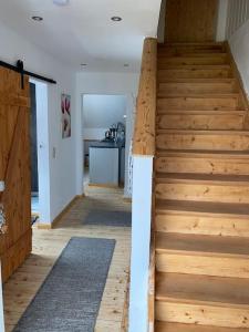escalera de madera en una habitación con cocina en Ferienwohnung Wolff am Natursteig Sieg und Westerwald, en Pracht
