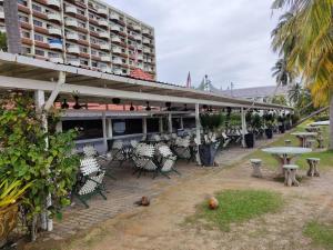 un patio con sillas y mesas y un edificio en Tanjung tuan regency private PD en Port Dickson