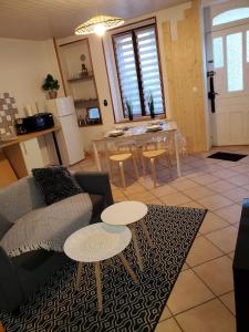 ein Wohnzimmer mit einem Sofa und einem Tisch in der Unterkunft Sélénite, Chaleureuse et Cocooning. in Braux