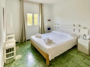 a white bedroom with a bed and a window at Casa frente al lago in La Savina