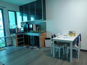 una cucina con tavolo e sedie bianchi in una stanza di MyHOMESTAY 2 @ Vista Bangi a Kajang