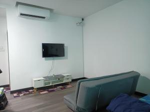 ein Wohnzimmer mit einem Stuhl und einem TV an der Wand in der Unterkunft MyHOMESTAY 2 @ Vista Bangi in Kajang