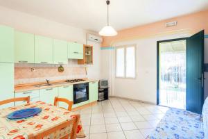 a kitchen with a table and a dining room at Orosei RE - Villa Osala - 800 m dal mare in Orosei