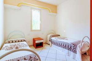 a room with two beds and a window at Orosei RE - Villa Osala - 800 m dal mare in Orosei