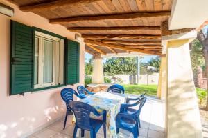 a table and chairs on the porch of a house at Orosei RE - Villa Osala - 800 m dal mare in Orosei
