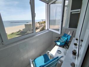 a balcony with chairs and a table and a view of the beach at Sunrise Beachfront Relax Studio in Constanţa