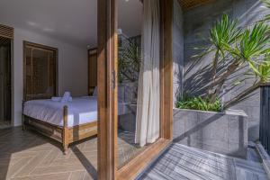 een slaapkamer met een bed en een glazen deur bij Le Boutique Danang in Da Nang