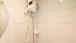a shower in a bathroom with a phone on the wall at Hotel Vanna Angeles City Pampanga by RedDoorz in Angeles