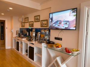 a kitchen with a counter with a tv on the wall at Batumi Next Sea Aparthotel in Batumi