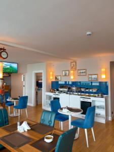 a living room with blue chairs and a kitchen at Batumi Next Sea Aparthotel in Batumi