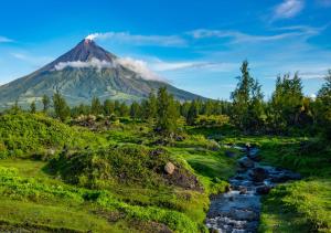 una montaña en la distancia con un río delante de ella en RedDoorz @ Arimbay Legazpi City, en Legazpi