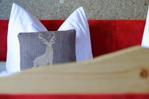 a bed with a pillow with a deer on it at Naturpension Max-Hütte in Breitenbrunn