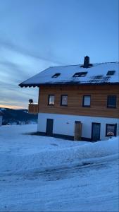 a house with a snow covered roof in the snow at Naturpension Max-Hütte in Breitenbrunn