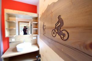 a bathroom with a wooden wall with a bike on it at Naturpension Max-Hütte in Breitenbrunn