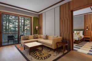 a living room with a couch and a bed at Hyatt Regency Dharamshala Resort in Dharamshala