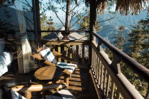een veranda met een bank en uitzicht op de bergen bij Sapa Jade Hill Resort & Spa in Sa Pa