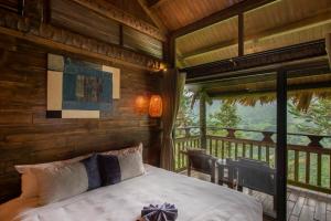 Sapa Jade Hill Resort & Spa في سابا: غرفة نوم مع سرير على شرفة