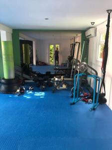 a gym with blue flooring and a man standing in the background at Belfast private room, en-suite & own access in Belfast