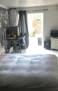 a bedroom with a bed and a table and a window at Belfast private room, en-suite & own access in Belfast