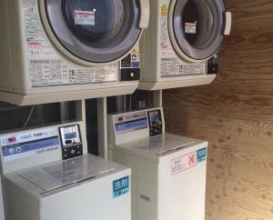 3 Waschmaschinen sind in einem Raum vorhanden in der Unterkunft Uno Port Inn in Tamano