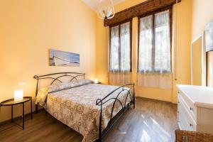 ein Schlafzimmer mit einem Bett und zwei Fenstern in der Unterkunft Villa Perondi in Lido di Camaiore