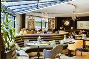 een restaurant met banken, tafels en stoelen bij Mercure Dijon Centre Clemenceau in Dijon