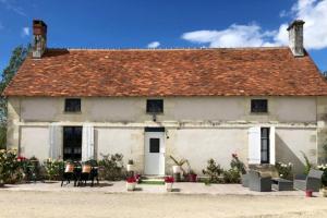 ein altes weißes Haus mit rotem Dach in der Unterkunft Villa d'une chambre avec piscine privee jardin amenage et wifi a Betz le Chateau in Betz-le-Château