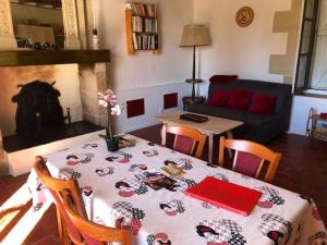 ein Wohnzimmer mit einem Tisch und einem Kamin in der Unterkunft Villa d'une chambre avec piscine privee jardin amenage et wifi a Betz le Chateau in Betz-le-Château