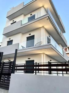 a tall white building with a fence in front of it at Noi leisure stay 3 in Neoi Epivates