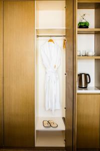 a closet with a robe and a pair of shoes at LDS Hotel Belgrade in Belgrade