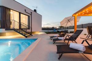 una casa y un patio con piscina y sillas en Villa Laurel, en Skradin