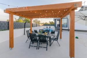 a patio with a table and chairs under a pergola at Villa Laurel in Skradin