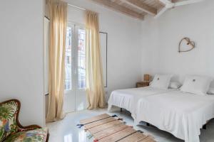 タリファにあるEl Erizo Apartamentosの白いベッドルーム(ベッド2台、椅子付)