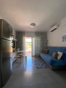 sala de estar con sofá azul y cocina en Bungalow Green Oasis Maspalomas, en Maspalomas