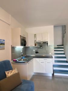 una cocina con armarios blancos y una escalera en Bungalow Green Oasis Maspalomas en Maspalomas