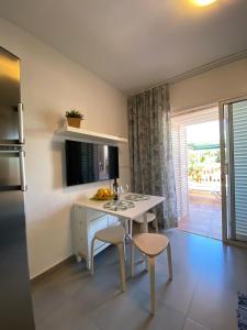 a kitchen with a table and chairs and a refrigerator at Bungalow Green Oasis Maspalomas in Maspalomas