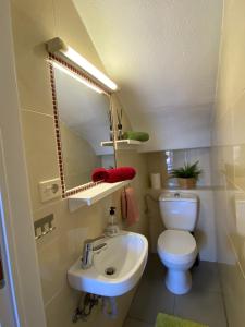 W łazience znajduje się umywalka, toaleta i lustro. w obiekcie Bungalow Green Oasis Maspalomas w mieście Maspalomas