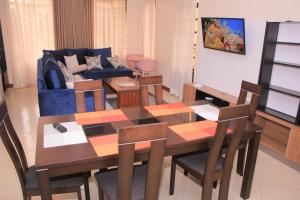 ein Wohnzimmer mit einem Tisch, Stühlen und einem Sofa in der Unterkunft BIDA FURNISHED APARTMENTS in Naivasha