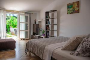 een slaapkamer met een bed, een tv en een raam bij Apartments Betty in Rovinj