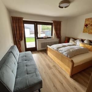 ein Schlafzimmer mit einem Bett und einem Sofa darin in der Unterkunft Ferienwohnung Waldblick in Kramsach