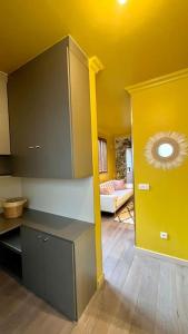 a room with a kitchen with a yellow ceiling at Luxury Copacabana proche Orly et Paris avec baignoire extérieur in Draveil +5 photos