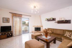 a living room with a couch and a table at Villa Evdokia in Limenaria