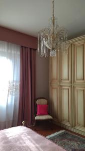 クアッラータにあるIl Gelsominoのベッドルーム1室(シャンデリア、ピンクの枕と椅子付)