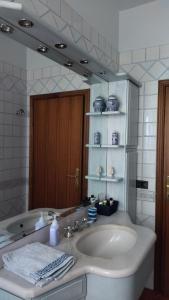uma casa de banho com um lavatório e um espelho grande em Il Gelsomino em Quarrata
