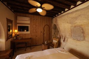 - une chambre avec un lit et un ventilateur de plafond dans l'établissement CEVHER KONAĞI, à Halfeti