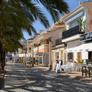 een straat met tafels, stoelen en gebouwen bij Modern apartment directly on the beach with WiFi and air conditioning in El Campello