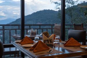 einen Tisch mit Tellern und Servietten auf einem Tisch mit Aussicht in der Unterkunft Mount Magnolia Boutique Hotel & Spa in Pelling