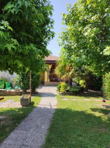 einen Gehweg, der zu einem Haus in einem Garten führt in der Unterkunft PERLA DEL DELTA in Loreo