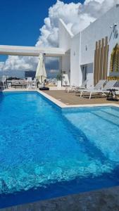 a large blue swimming pool with chairs and a building at Brickell Hotel apto g 08 Santo Domingo Bella Vista in Santo Domingo